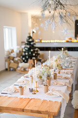 Christmas decoration of the festive table with cakes, glasses and candles