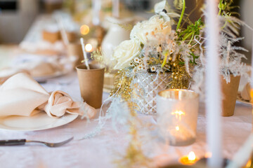 Christmas decoration of the festive table with cakes, glasses and candles