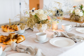 Christmas decoration of the festive table with cakes, glasses and candles