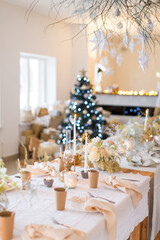 Christmas decoration of the festive table with cakes, glasses and candles