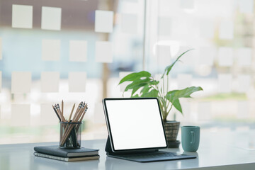 Fototapeta premium View of portable workspace with digital tablet, stationery, and coffee mug on the table.