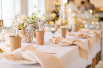 Christmas decoration of the festive table with cakes, glasses and candles