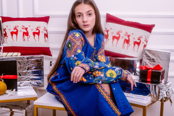  teenager in embroidered clothes surrounded by gifts.time for gifts