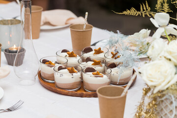 Christmas decoration of the festive table with cakes, glasses and candles