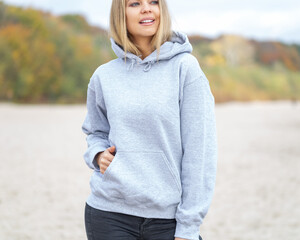 Woman wear hoodie on the beach - obrazy, fototapety, plakaty