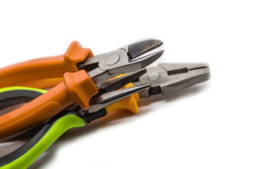 pair of pliers with bright orange and green rubber handles on a white background