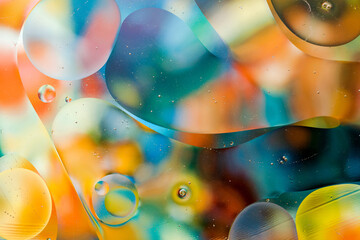 Close-up of the movement of oil droplets on the water surface. Colorful abstract macro background...