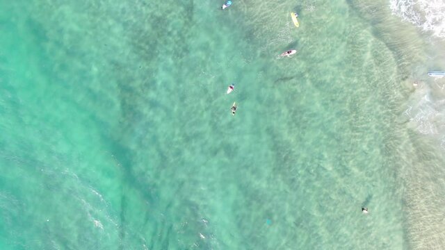 Top-down view of azure waves and surfers on the Mediterranean Sea. Netanya  Israel