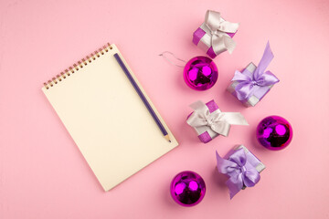 top view little presents with notepad and toys on pink background photo color new year christmas gift family