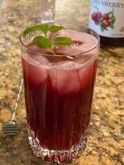 holiday red cocktail with ingredients in the background 
