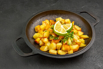front view tasty fried potatoes inside pan with lemon on dark background cuisine photo color food meal