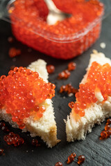 Fresh red caviar on spoon and piece of bread