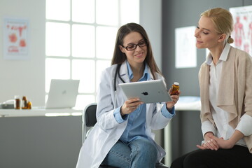 Doctor and patient discussing something while sitting at the table . Medicine and health care concept - 399785873