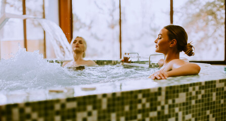 Young women relaxing in the whirlpool bathtub at the poolside