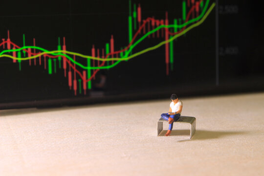 Simple Conceptual Photo, illustration for Young Man Investor Mini Figure Toy businessman Seriously watching Running Stock Exchange Sitting at stappler