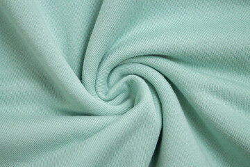 Background of light green fabric sample from above view