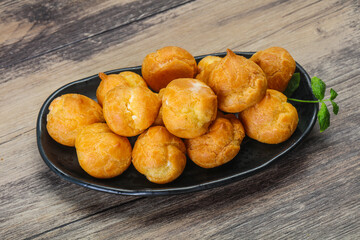 Sweet tasty profiteroles heap in the bowl