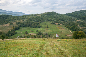 Fototapeta premium country road in the carpathian mountains and a small white church