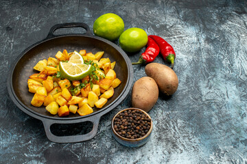 front view tasty fried potatoes with lemon and peppers on grey background photo food fry cooking color