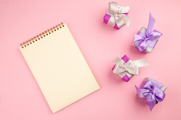 top view little presents with notepad on a pink background photo color new year christmas gift family