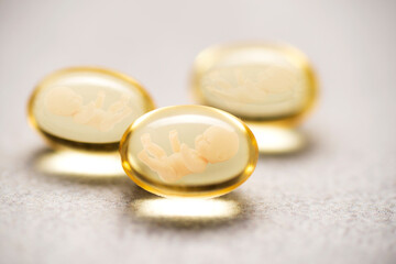 Artificial insemination. Pregnancy pills, yellow pills with baby doll silhouette. Baby test tube, IVF concept