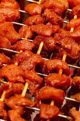 meat in spices on wooden skewers is cooked on coals and smoke