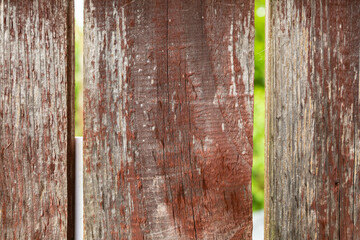 old and weathered wooden fence boards with large gaps on a green lawn background