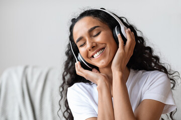 Joyful young woman in headphones listening to music