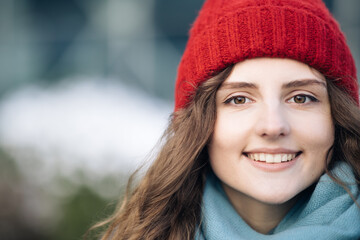 CLose up Portrait young attractive curly haired smile woman with red hat look at camera at city center feel happy. Fshion girl. Stand on street