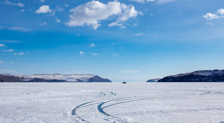 Fototapeta na wymiar Beautiful winter landscape of frozen Lake Baikal. Car driving on ice. Winter holidays.