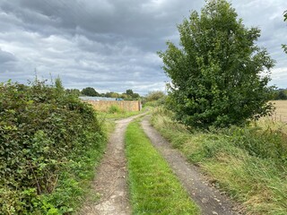 Old cart track, leading off, Santingley Lane, with trees, outbuildings and fields, on a cloudy day in, Crofton, Wakefield, UK