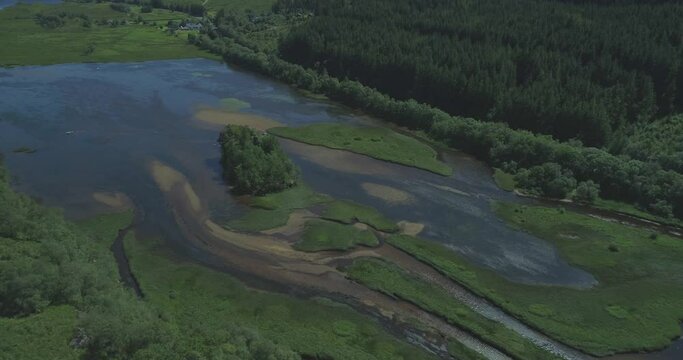 High aerial of island in the middle of Loch Dochart in the Scottish Highlands surrounded by lush green forests