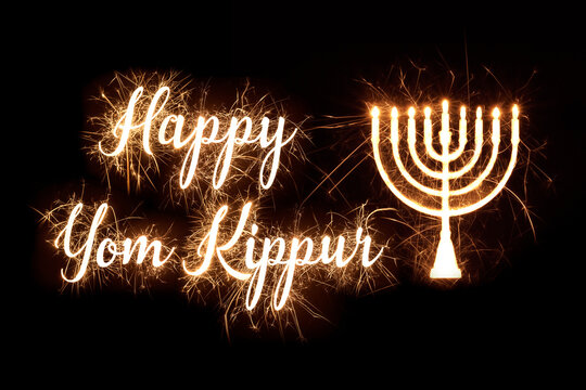 Happy Yom Kippur in dazzling sparkler effect on dark background