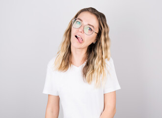 Tired sleepy woman stuck out her tongue from fatigue, has sad expression, difficult at work. Isolated over white background