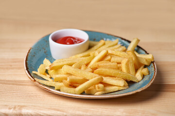 French fries on the plate standing the wooden table