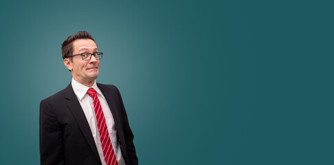 Angst vor der Zukunft? Verunsicherter Mann im Anzug vor grünen Hintergrund