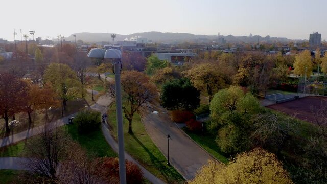 Drone flying over a public parc in Montreal with sports field and pedestrians
