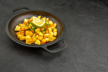 front view tasty fried potatoes inside pan with lemon slices on dark background photo cuisine meal color