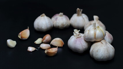 garlic cloves and bulb with copy space on dark background.