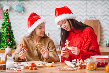 Happy family mother and daughter bake cookies for Christmas