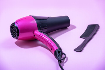 Hair dryer, Comb and hair brush on a pink background. Professional hairdresser set. Tools necessary for hair care.
