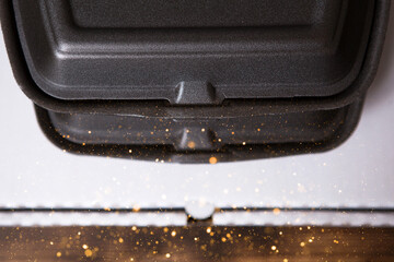 Food delivery containers and a pizza box are stacked. Food delivery service, ready-made hot order, single-use plastic and paper packaging, non-ecological garbage, clogging and recycling. Copy space