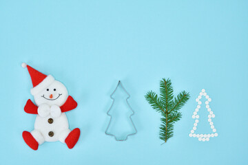 Snowman figurine and Creative Christmas tree made of pills on blue background. Spruce twigs. New Year, Christmas card.