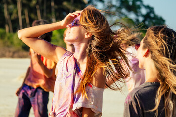Naklejka premium multinational multicultural mixed race friends in holi dust on beach in Goa