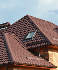 A close-up of a metal roofing waterproofing problem area with roof flashings, a complex roof with...