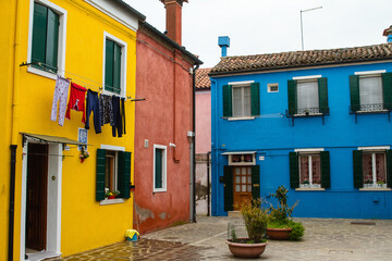 Venice : Burano island street with colorful houses and clothes drying on the windows
