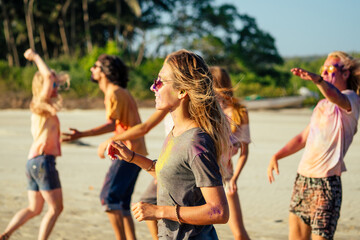 happy people in colorful holi paint play on beach on festive in Goa beach India