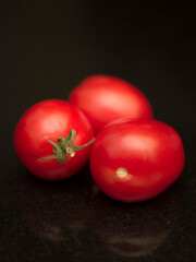 A Roma tomato with black background