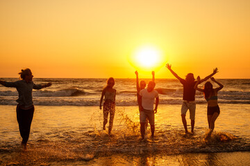multicultural multinational happy people running into the sun carefree and happiness, vacation on sea