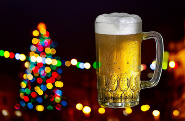 Glass of beer on the dark background with Christmas tree
